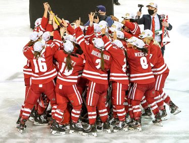 UW Women's hockey team embraces on the ice