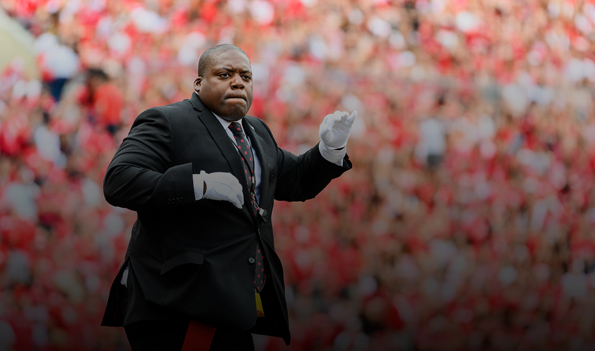 Corey Pompey against the background of stands filled with Badger fans, directs the UW Marching Band