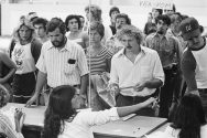 1980s black and white photo of students waiting in line at a table to register for classes