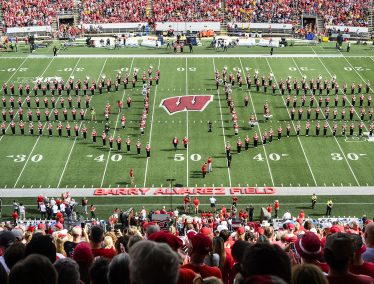 The UW Marching band in formation as new Barry Alvarez Field sign shows on Camp Randall field