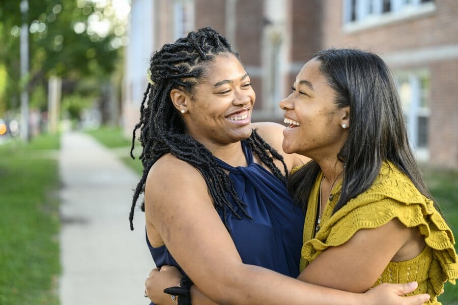 Sisters Eryne and Sydne Jenkins smile at one another as they embrace