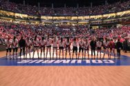 The Badgers Women's volleyball team stands in a row on the Nebraska court during the national championship