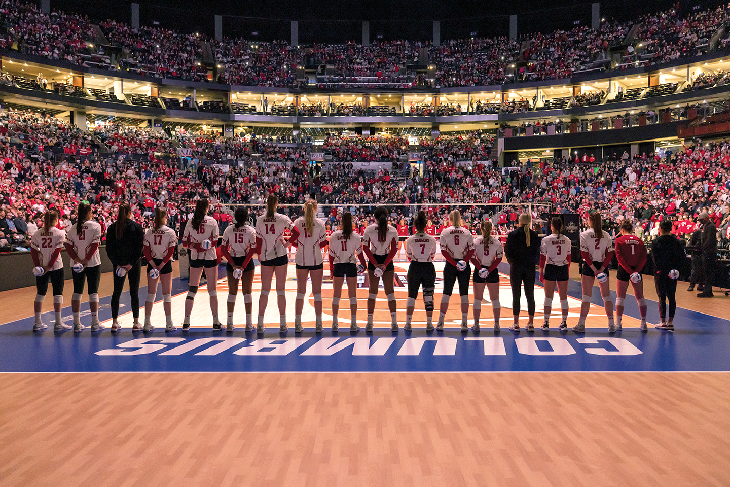 The Badgers Women's volleyball team stands in a row on the Nebraska court during the national championship