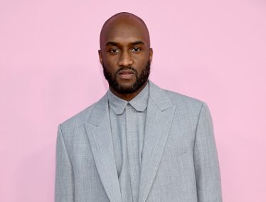 Virgil Abloh wearing a gray suit against a pink background