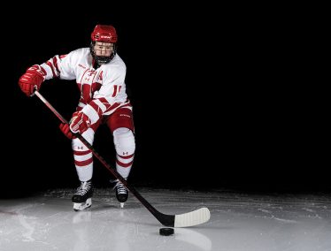 Daryl Watts on ice wearing hockey uniform and holding hockey stick