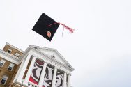 Grad cap is tossed into the air in front of Bascom Hall