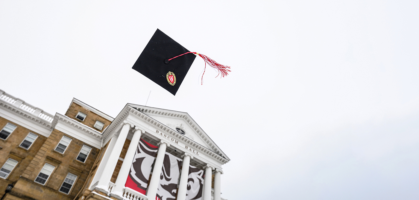 Grad cap is tossed into the air in front of Bascom Hall