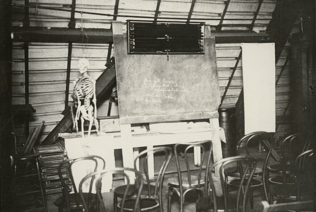 Historical black and white photo of the Science Hall attic with a human skeleton on display