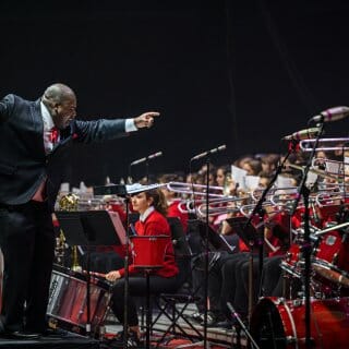 Corey Pompey, Director of Athletic Bands and Associate Director of Bands, enthusiastically leads UW Varsity Band Spring Concert dress rehearsal in the Kohl Center
