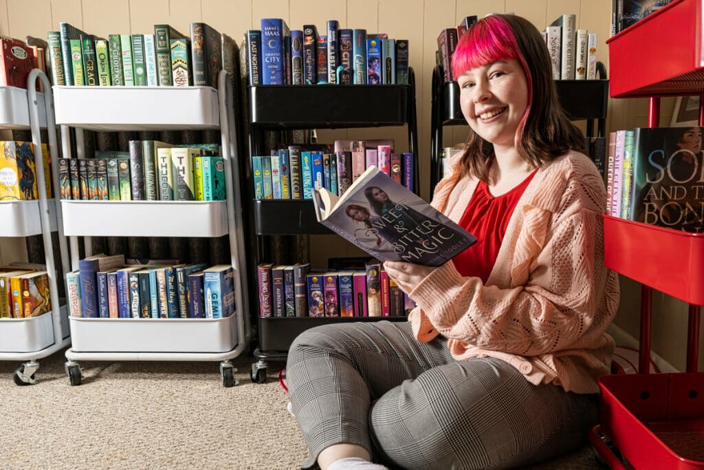 Kyla Vaughn sits in front of bookshelves full of books
