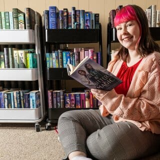 Kyla Vaughn sits in front of bookshelves full of books