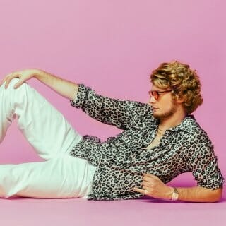 Matthew Hauri, as "Yung Gravy", poses against a pink background