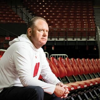 Greg Gard sits in the empty stands of the Kohl center