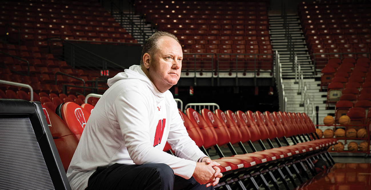 Greg Gard sits in the empty stands of the Kohl center