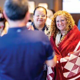 Chancellor Jennifer Mnookin wears a blanket presented to her by members of the Ho Chunk Nation