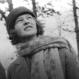 Black and white photo of Mildred wearing hat and scarf