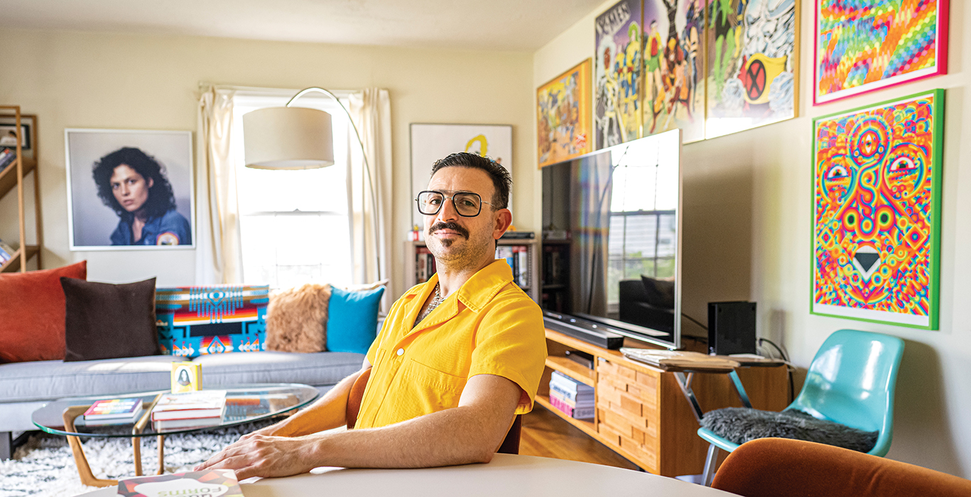 Ramzi Fawaz wearing a bright yellow jumpsuit, in his living room