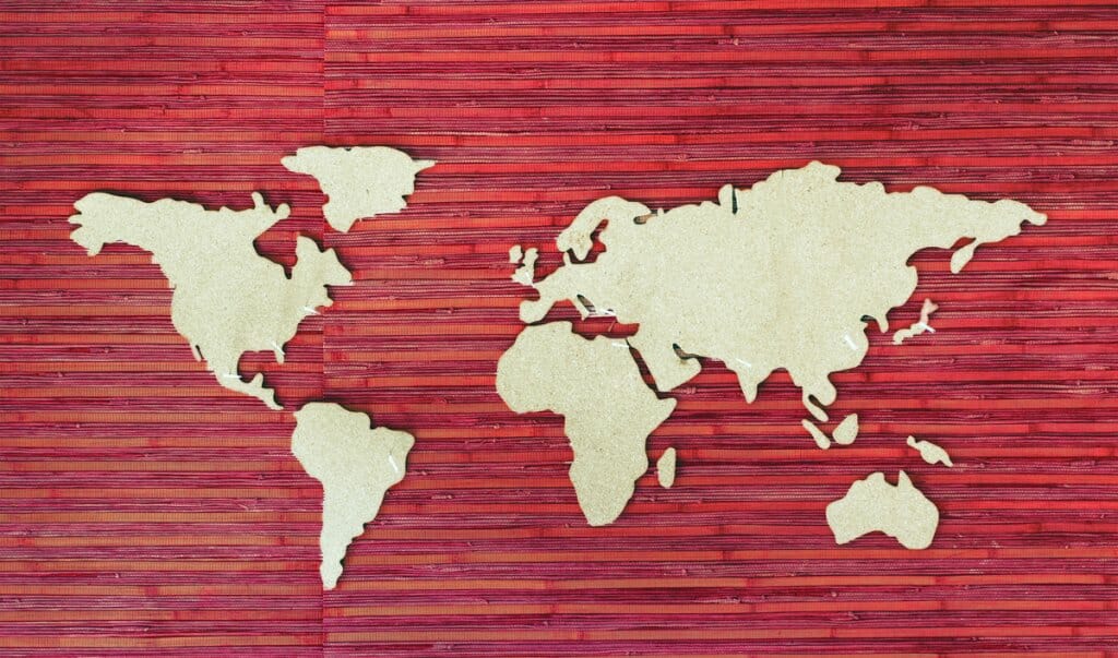 Stylized photo of red and white world map made out of cork and natural materials