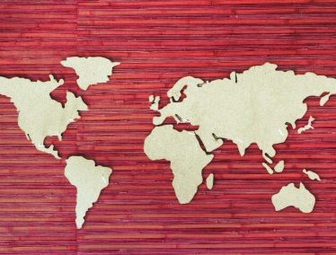 Stylized photo of red and white world map made out of cork and natural materials