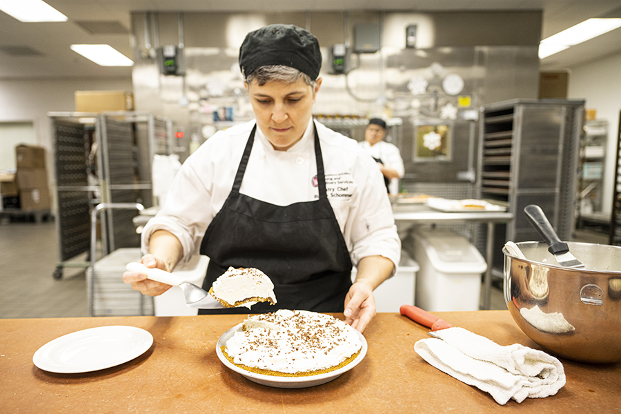 Pastry chef scoops out a piece of finished fudge-bottom pie ready to serve