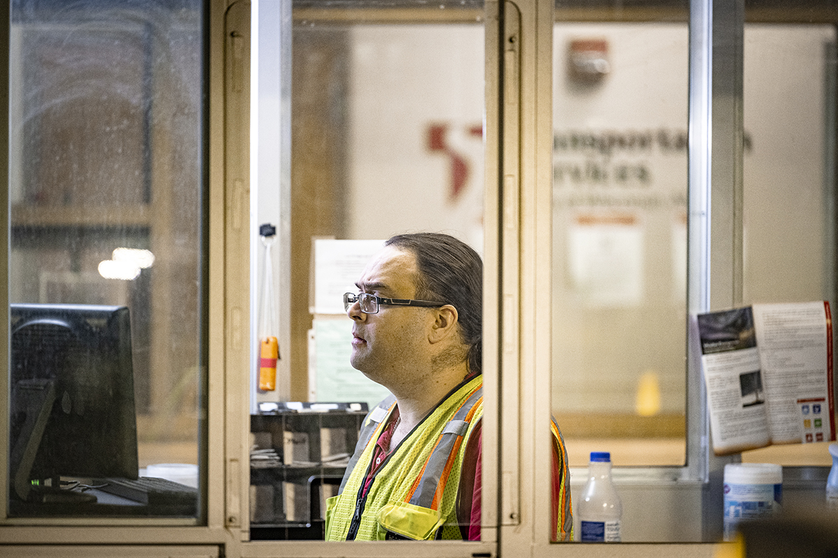Matt Finch wearing a reflective vest seen through a parking attendant partition