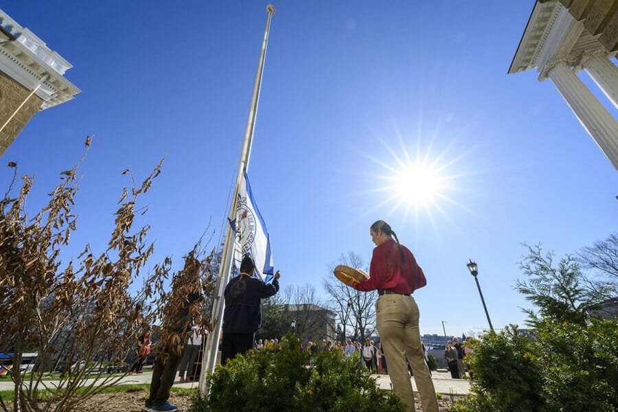 From right to left, Cordell Funmaker, Ho-Chunk Nation tribal member; Marcus WhiteEagle, Ho-Chunk marine veteran; and Marlon WhiteEagle, president of the Ho-Chunk Nation and marine veteran; play the hand drum and raise the Ho-Chunk Nation’s flag in front of Bascom Hall at the University of Wisconsin–Madison on April 12, 2023. The campus inhabits land that was the ancestral home of the Ho-Chunk people, land they call Teejop (Dejope, or Four Lakes). The flying of the Ho-Chunk Nation flag is part of the university’s ongoing commitment to educate the campus community about Ho-Chunk culture and First Nation’s history and is part of Investiture, a series of special campus events planned for April 10-15 to celebrate the university and formally welcome Jennifer L. Mnookin as chancellor and the 30th leader of the UW–Madison. (Photo by Althea Dotzour / UW–Madison)