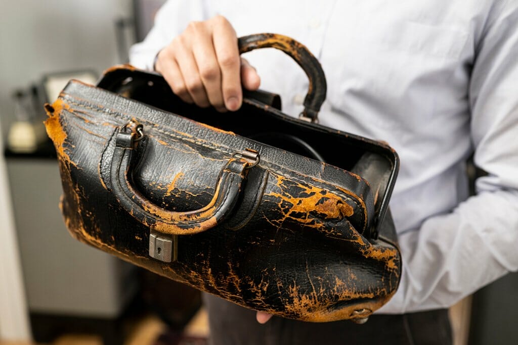 Chin holds a worn, black physician’s satchel.