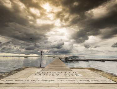Sunlight peeks through as storm clouds roll in over Lake Mendota near the Goodspeed Family Pier along the Memorial Union Terrace.