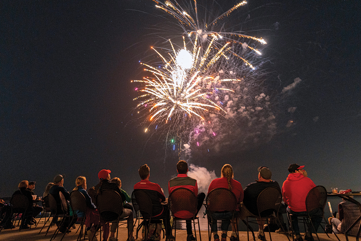 Onlookers watch fireworks over Lake Mendota during the 2022 Homecoming celebration
