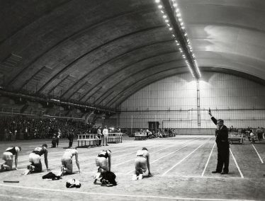 Black and white photo of runners crouched and ready for a race on the track inside the Shell