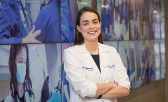 Olivia Rater smiling and wearing a white doctor's coat