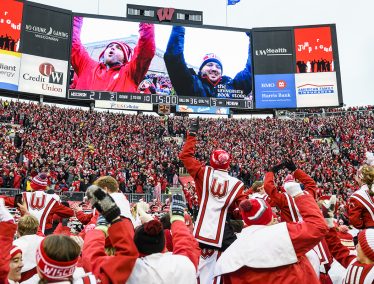 The UW Marching band cheers with a crowd of Badger fans in the stands of Camp Randall