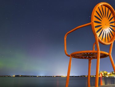 Orange Terrace chair against night sky over Lake Mendota