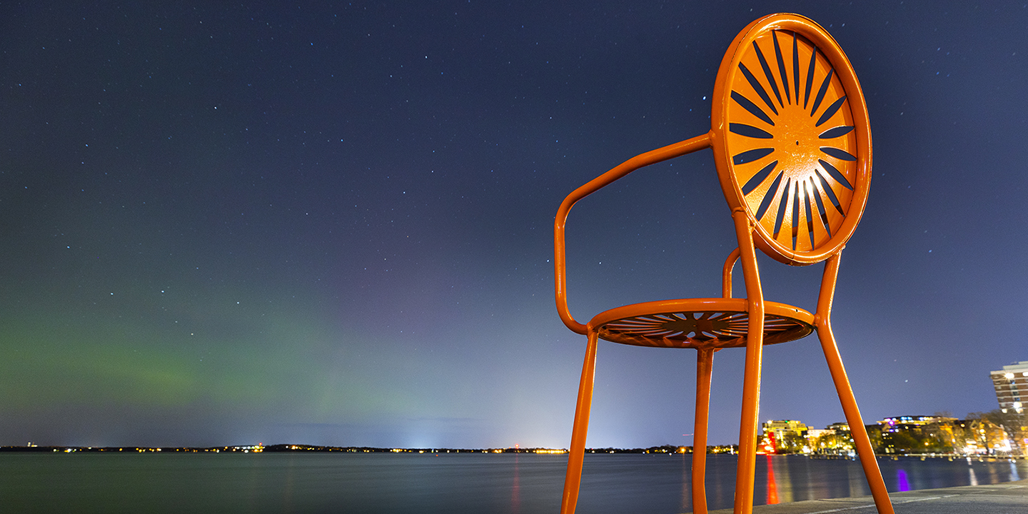 Orange Terrace chair against night sky over Lake Mendota