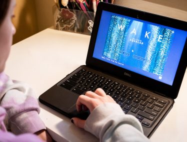 A person is playing the smilulation game, Wake, on a laptop.