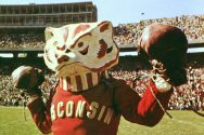 An archival photo of a Bucky mascot leading cheers at Camp Randall Stadium