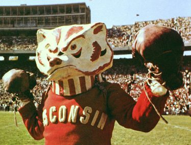 An archival photo of a Bucky mascot leading cheers at Camp Randall Stadium