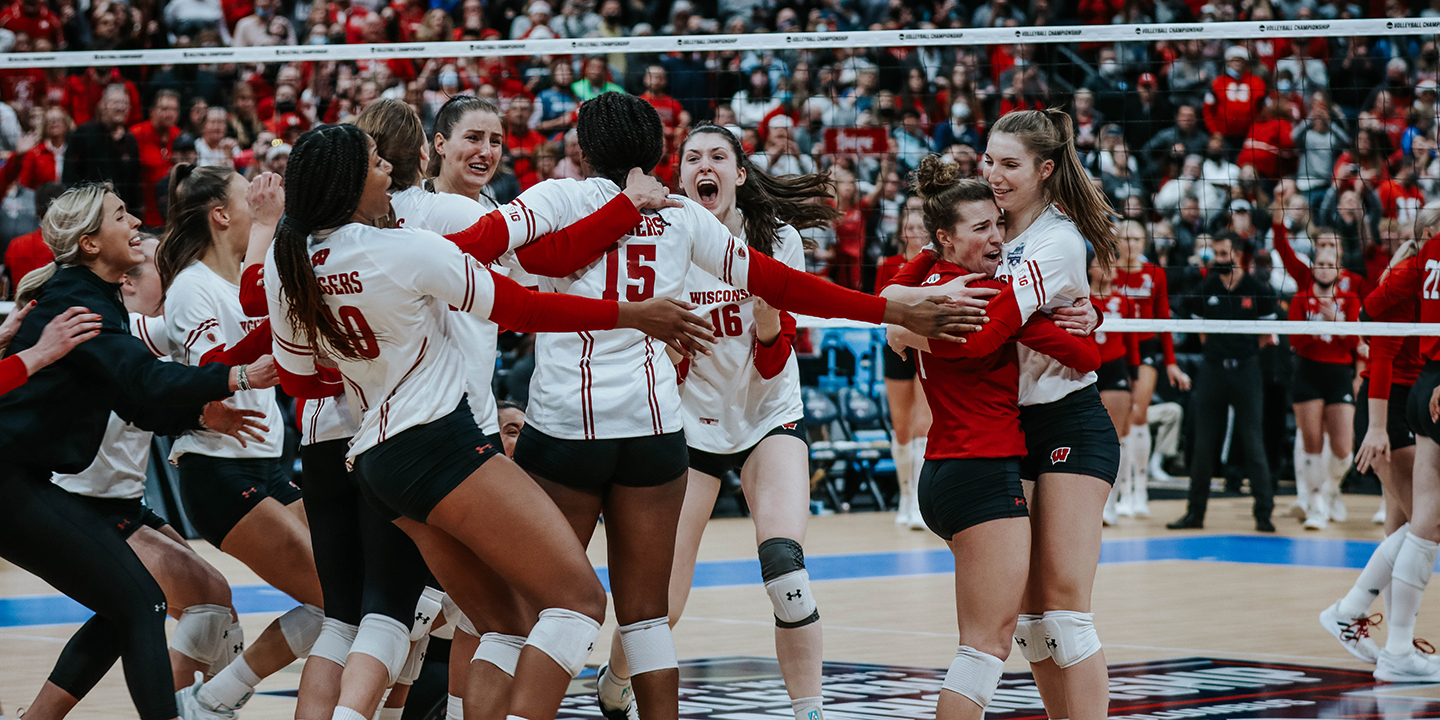 The UW Women's Badger volleyball team celebrates on the court after winning a championship match.