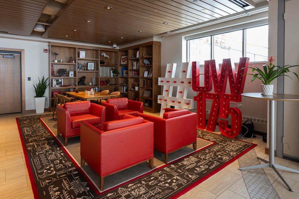 The alumni library features a sitting area and reading material on shelves