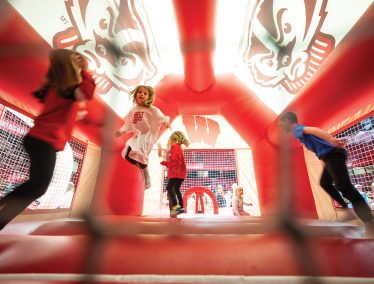 Children play in a red Bucky Badger themed bounce house