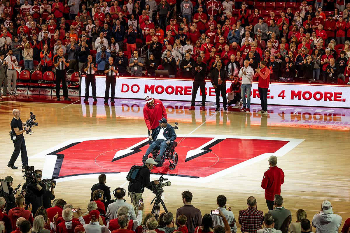 Howard Moore, in a wheelchair, in the center of the basketball court at the Kohl Center.