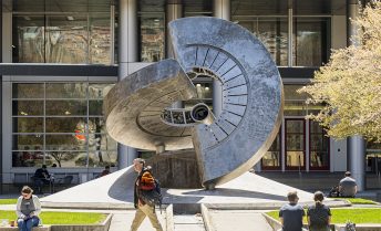 A student walks in front of the Maquina sculpture on Engineering Mall