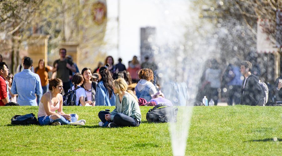 UW students and pedestrians enjoy a warm spring day near the fountain on Library Mall