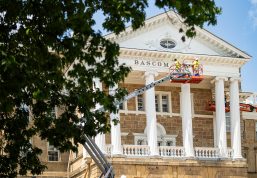 Working in aerial lifts, workers apply a fresh coat of white paint to the exterior of Bascom Hall.