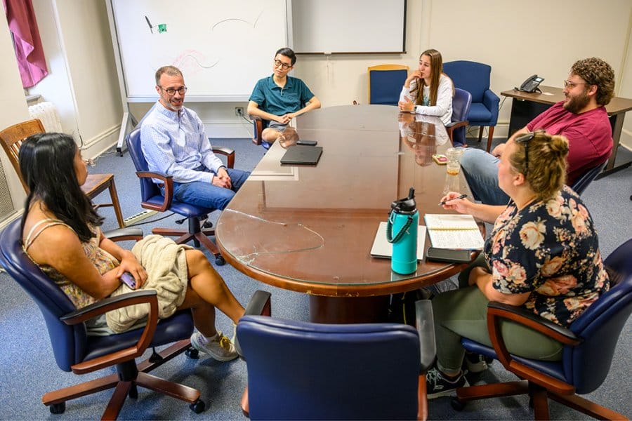 Graduate students sit around a boardroom-style table with Barry Burden.