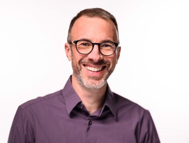 Headshot of Barry Burden, smiling and wearing a purple button-up shirt.