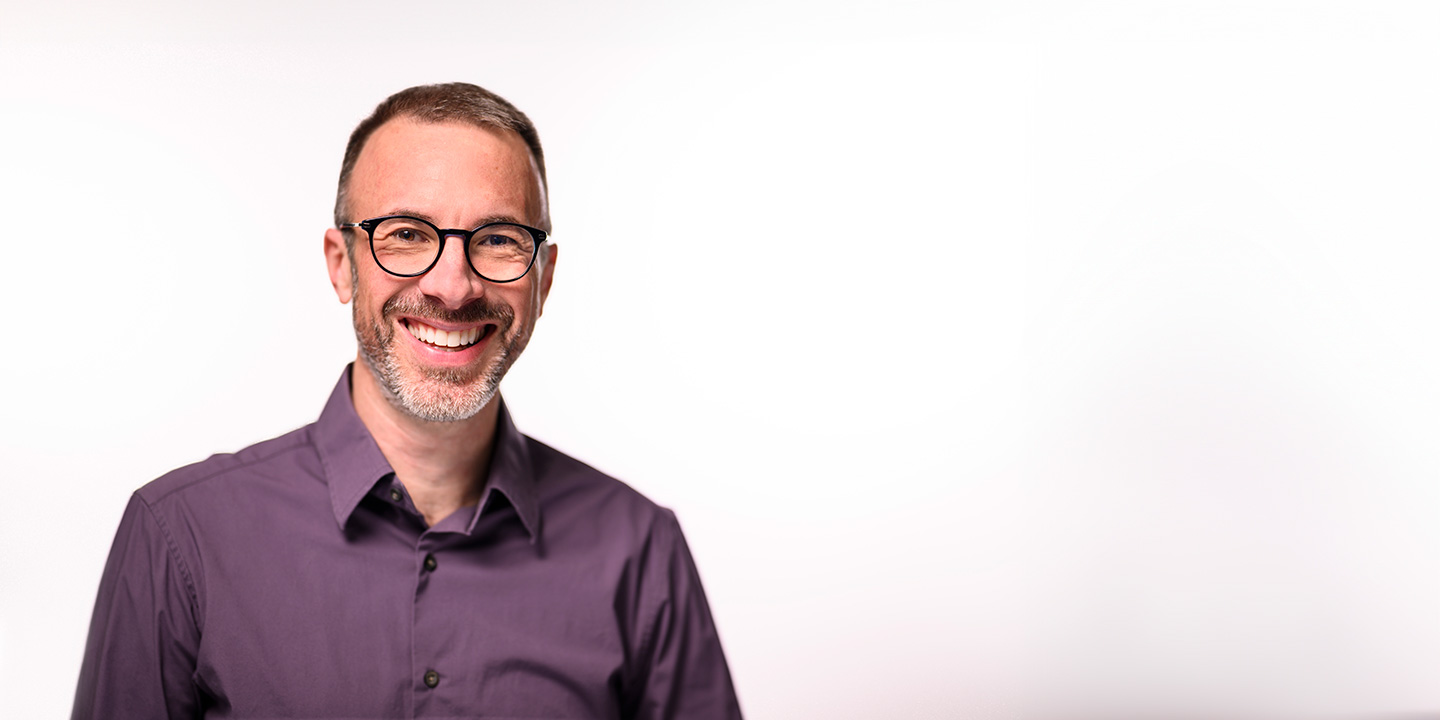 Headshot of Barry Burden, smiling and wearing a purple button-up shirt.