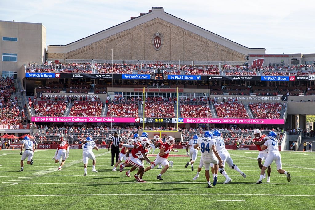 A scene from a Badger Football game, with fans seated in the background.