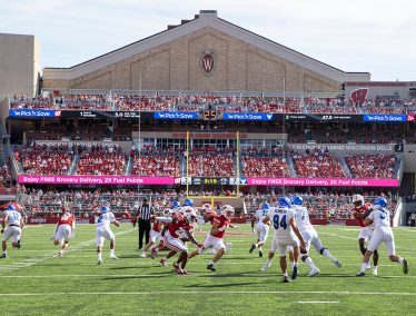 A scene from a Badger Football game, with fans seated in the background.