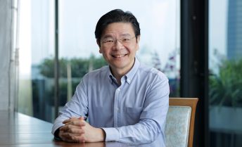 Headshot of Lawrence Wong seated at a table, smiling at the camera.